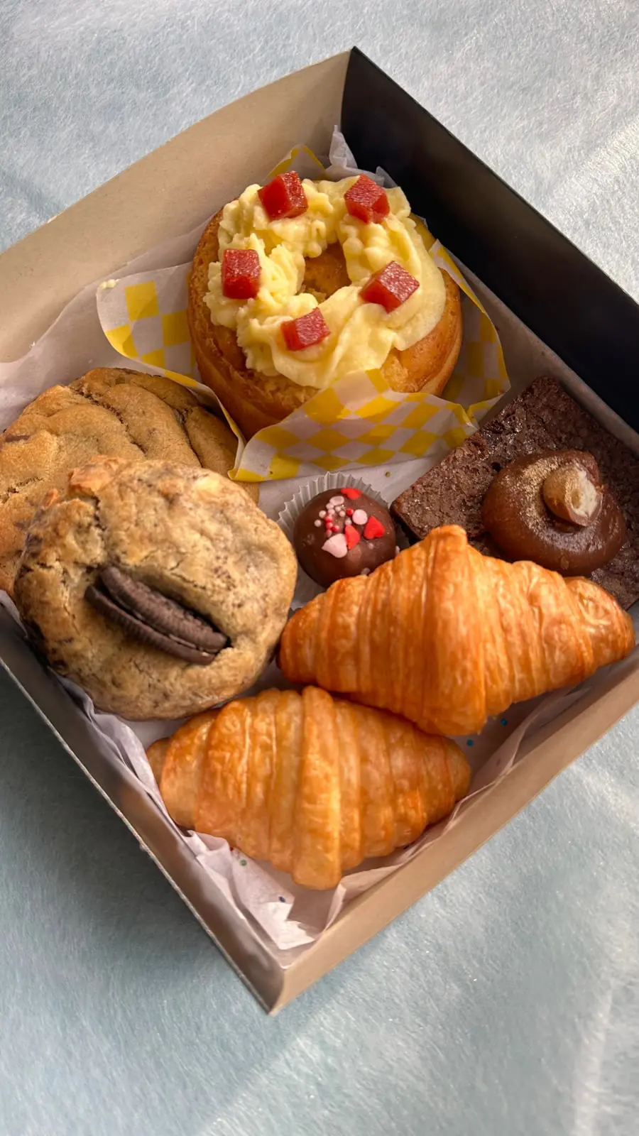 Caja Deluxe abierta con torta personal, brownie, galletas y croissants